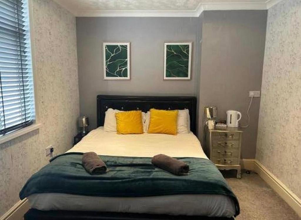 a bedroom with a large bed with yellow pillows at Cherish Lewis Hotel- Hull Road, Blackpool Central in Blackpool