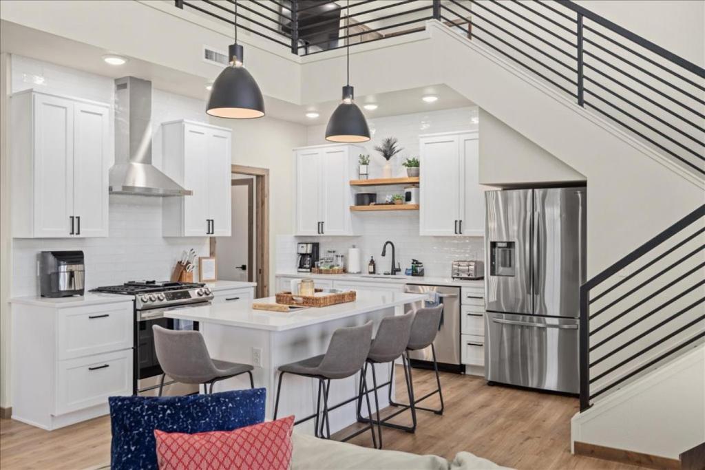 a kitchen with white cabinets and a kitchen island with bar stools at Yellowstone Yonder Red Lodge in Red Lodge