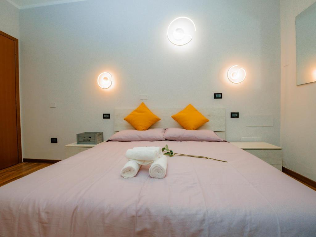a bedroom with a large white bed with towels on it at LA CORTE CHARME Diaz in Ravenna