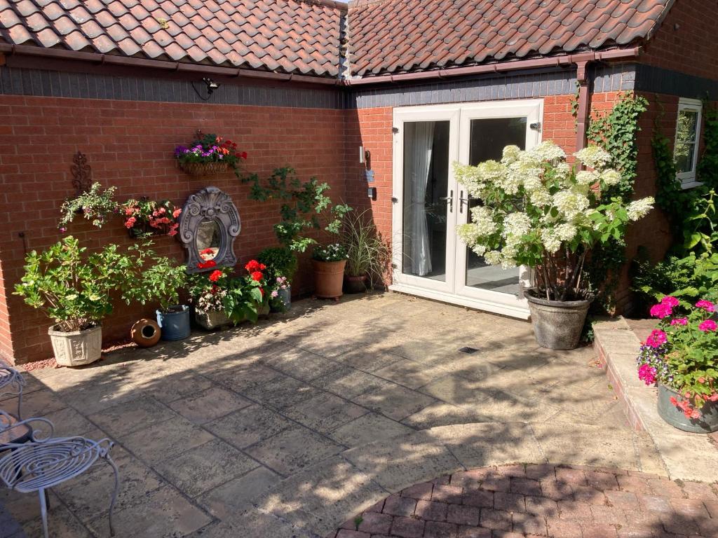 a house with a bunch of potted plants in front of a door at The Gardens Room in Upton