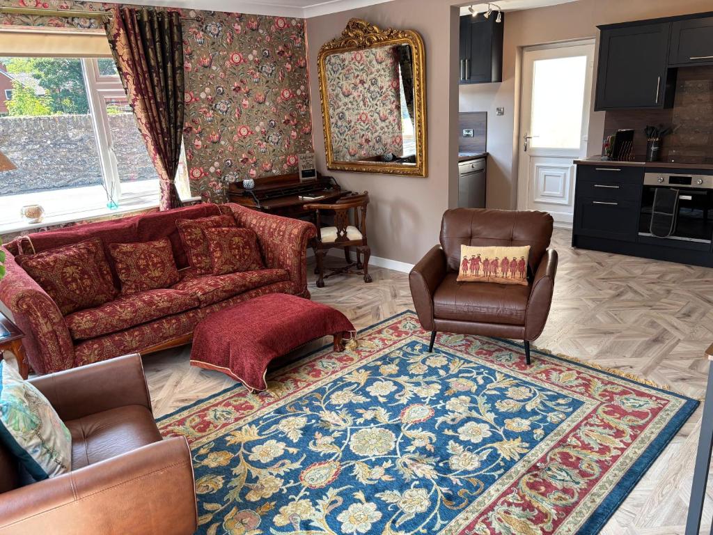 a living room with a red couch and chairs at Cerrig in Llangollen
