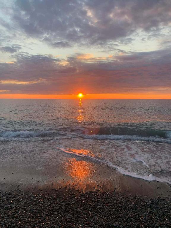 a sunset on a beach with the ocean at LouNik stay hotel and rooms in Kobuleti
