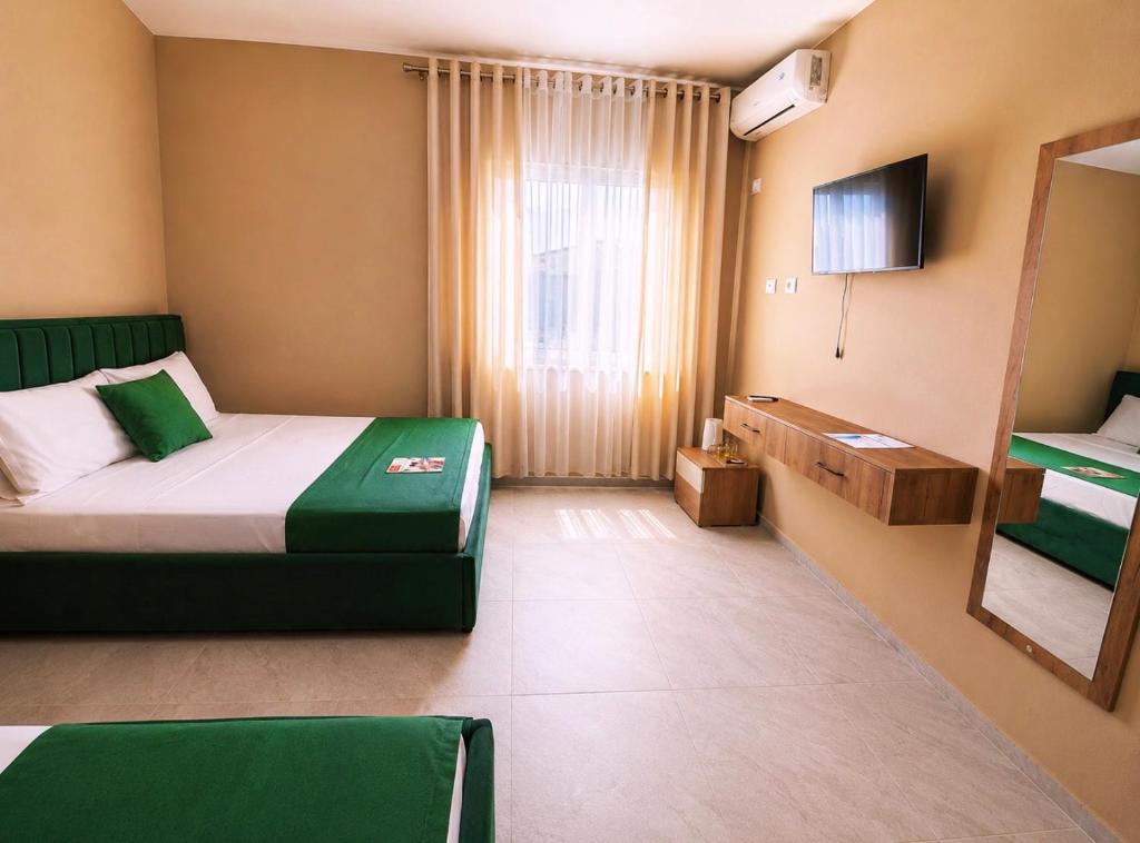 a hotel room with a bed and a window at Nova Rooms Velipojë in Velipojë