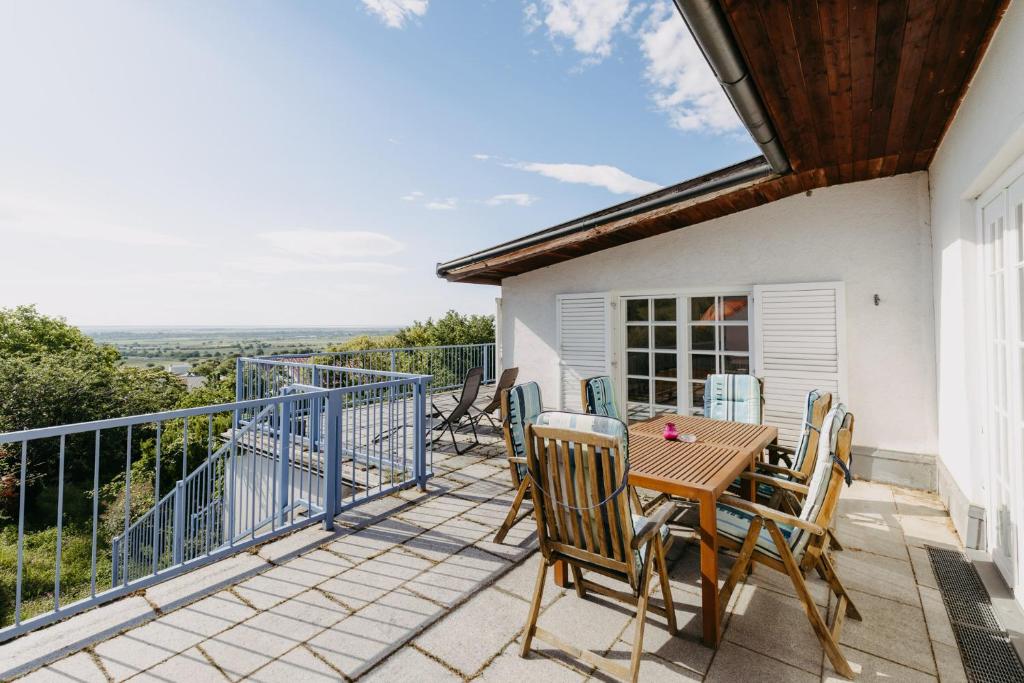 a patio with a table and chairs on a balcony at Villa Vista Pannonia in Donnerskirchen