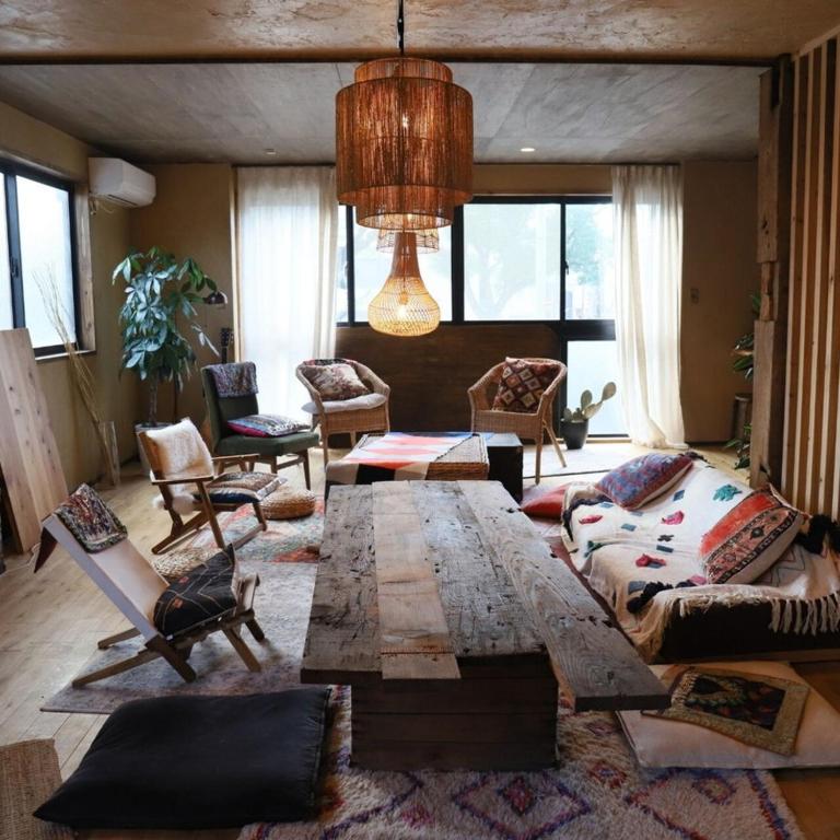 a living room with a large wooden table and chairs at ゲストハウスよるよなか in Nagoya