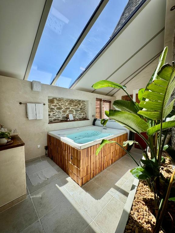 a bathroom with a hot tub in a room with a window at Le Pré de la Mer Suite & SPA Privatif in Querqueville