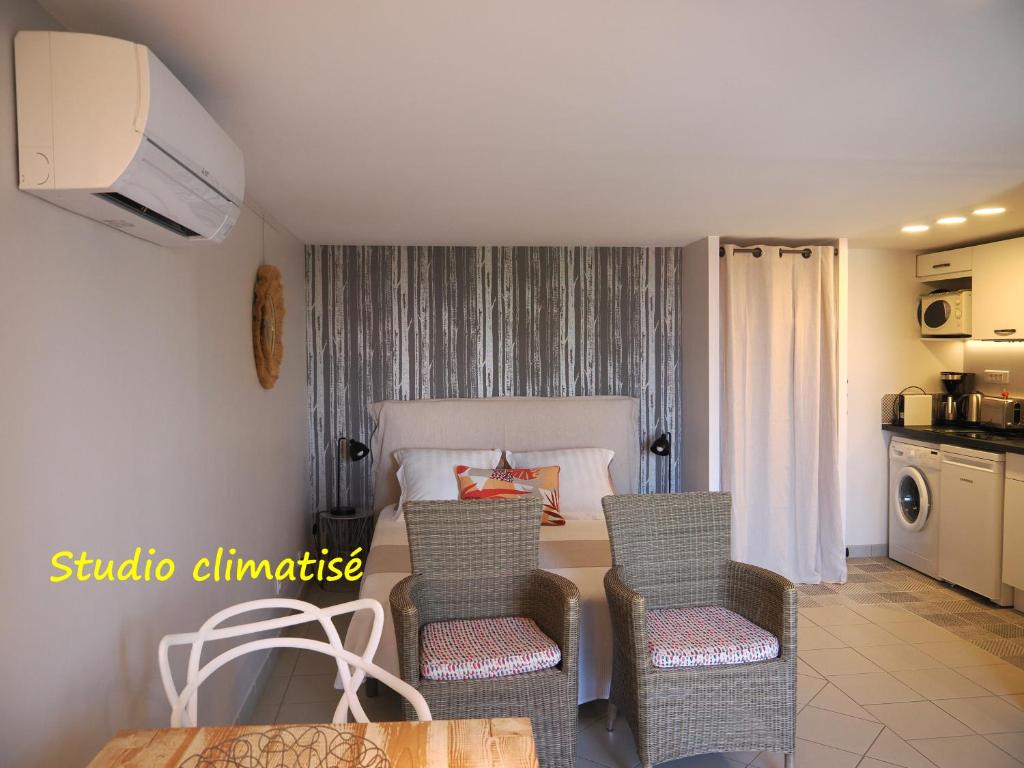a room with a bed and a table and chairs at Une Heure Bleue in Manosque