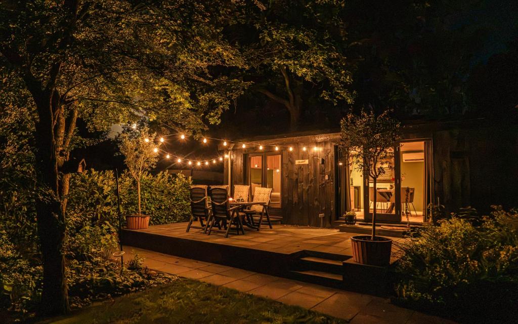 a house with a patio at night with lights at Meikever in Putten