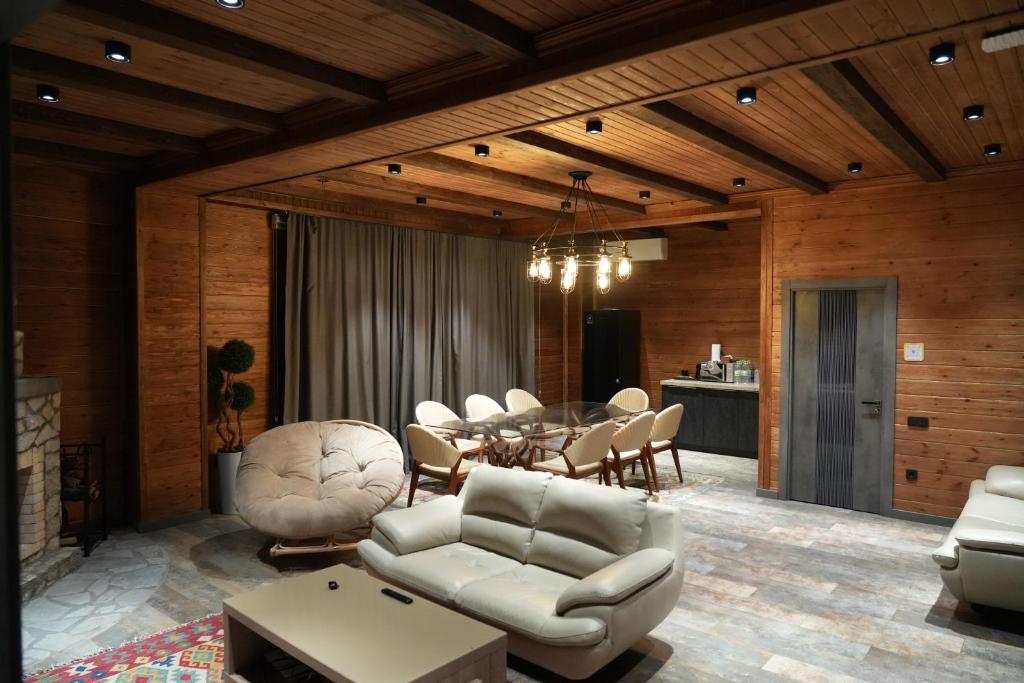 a living room with a table and white chairs at Fayz Mount Residence in Chimgan