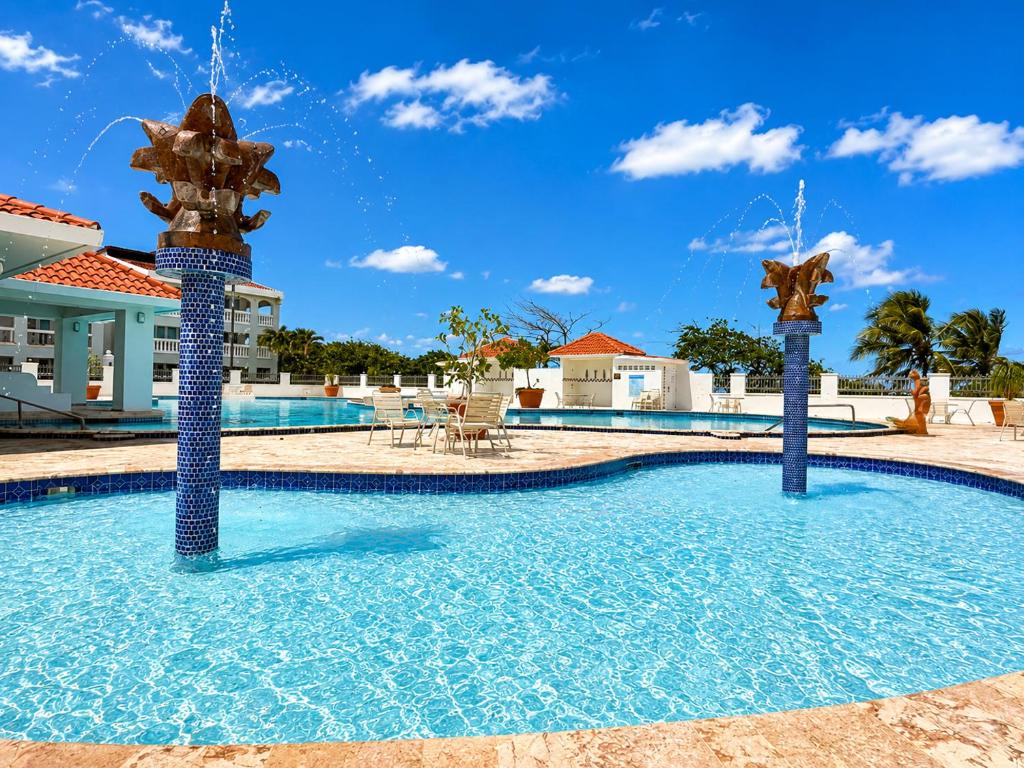 a swimming pool with two water fountains at Golden Dream Studio 2nd floor B in Isabela