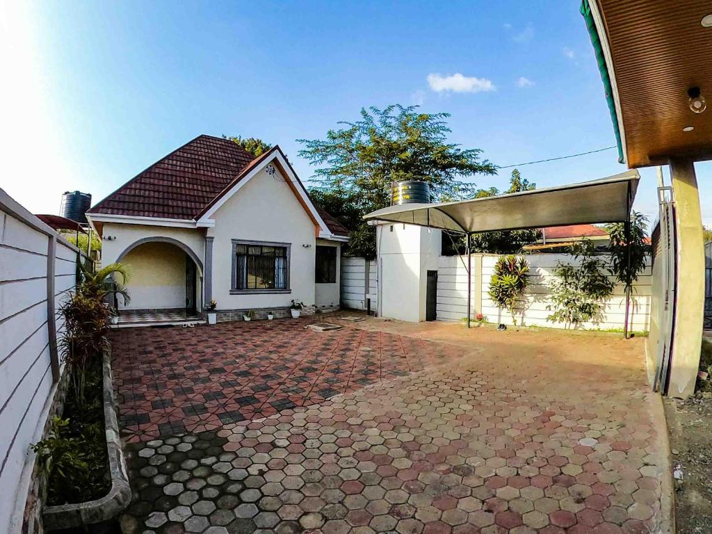 a white house with a brick driveway at Makali Private Villa- 2En-Suite Bedrooms in Arusha