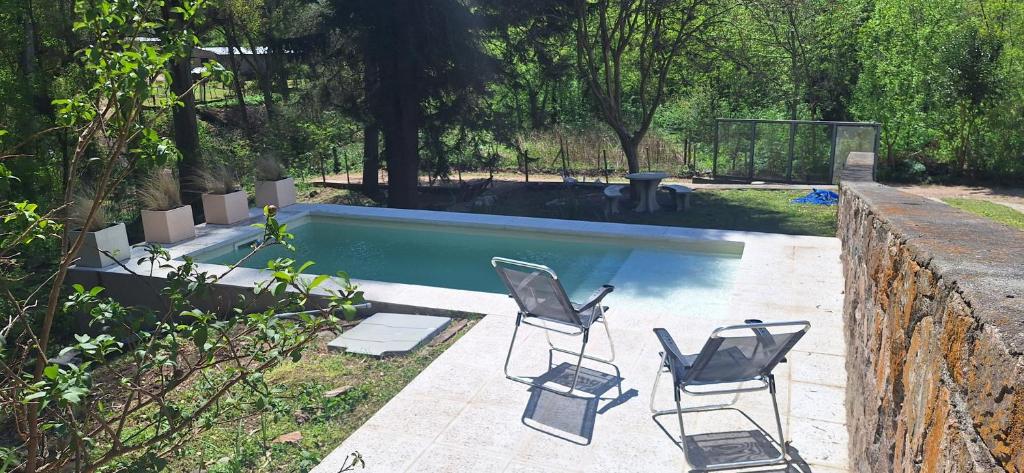 a group of chairs sitting next to a swimming pool at Casa en Camino del cuadrado Sierras de Córdoba in Río Ceballos
