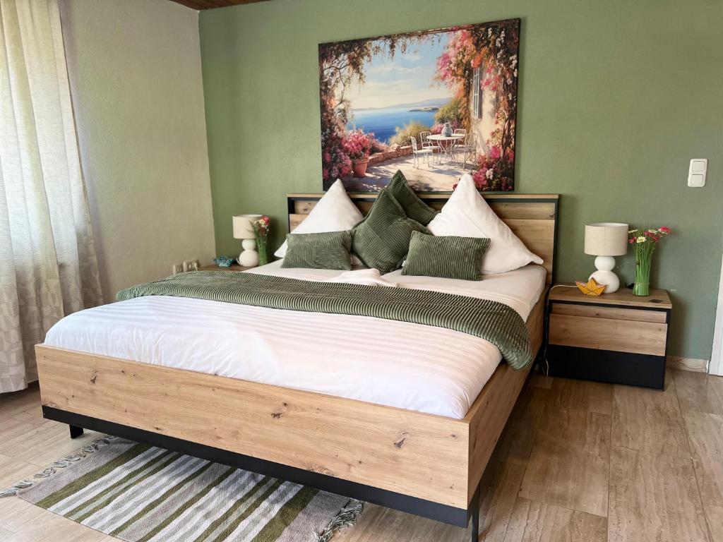 a bedroom with a large bed with a painting on the wall at Apartment Leidenberger - Nähe Rothenburg & Ansbach - 2 Schlafzimmern in Colmberg