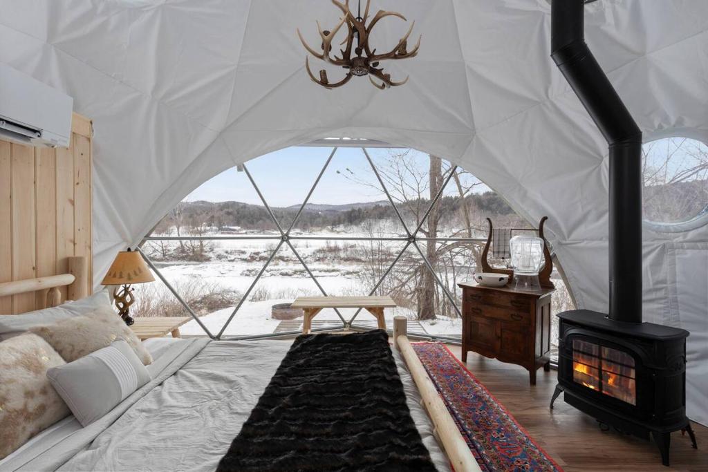 a bedroom with a tent with a fireplace in it at Johnson Dome in Johnson