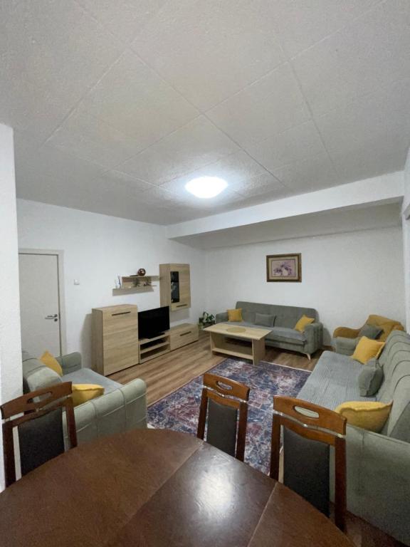 a living room with couches and a table and a kitchen at Bleon Apartment in Prizren