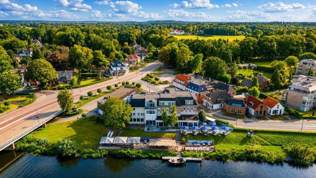 an aerial view of a large house on a river at Hotel de Zon - Brasserie Bresson by Flow in Ommen