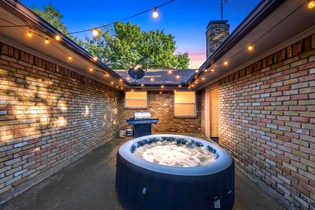 a hot tub in a brick wall with lights at FIFA World Cup Backyard Retreat in Dallas