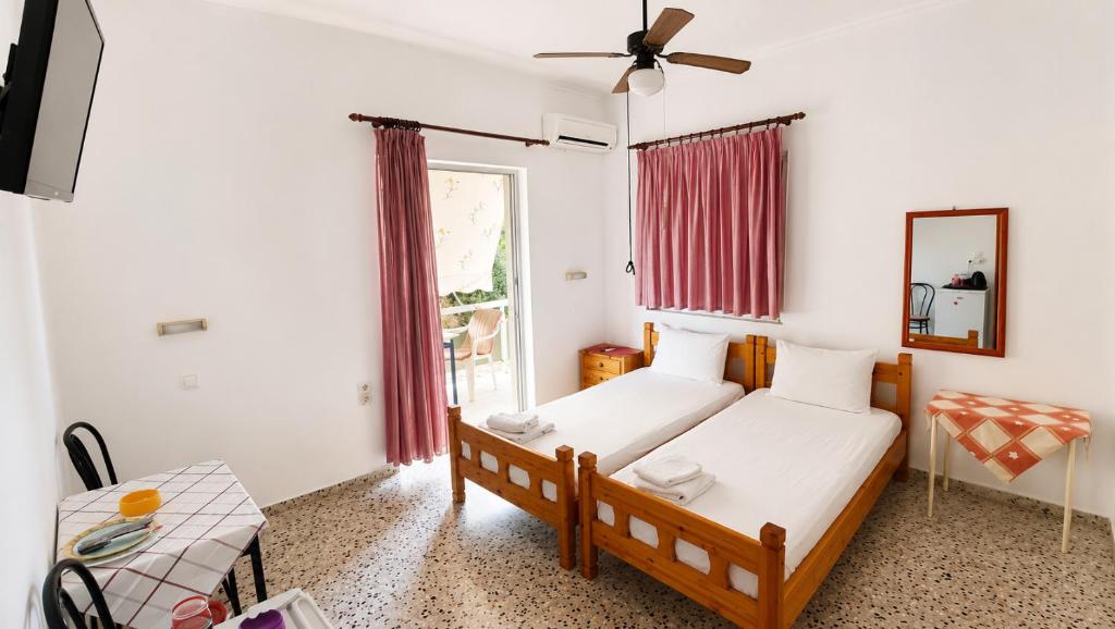 a bedroom with two beds and a window at Pension Vienna in Methana
