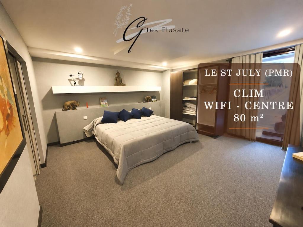 a bedroom with a large bed with blue pillows at Le Saint July in Eauze
