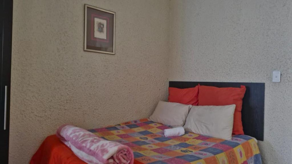 a bedroom with a bed with a colorful comforter at Millys Guesthouse Jhb in Johannesburg