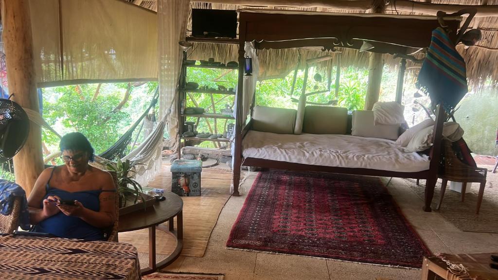 a woman sitting in a room with a bed at Casa Alma in Sayulita