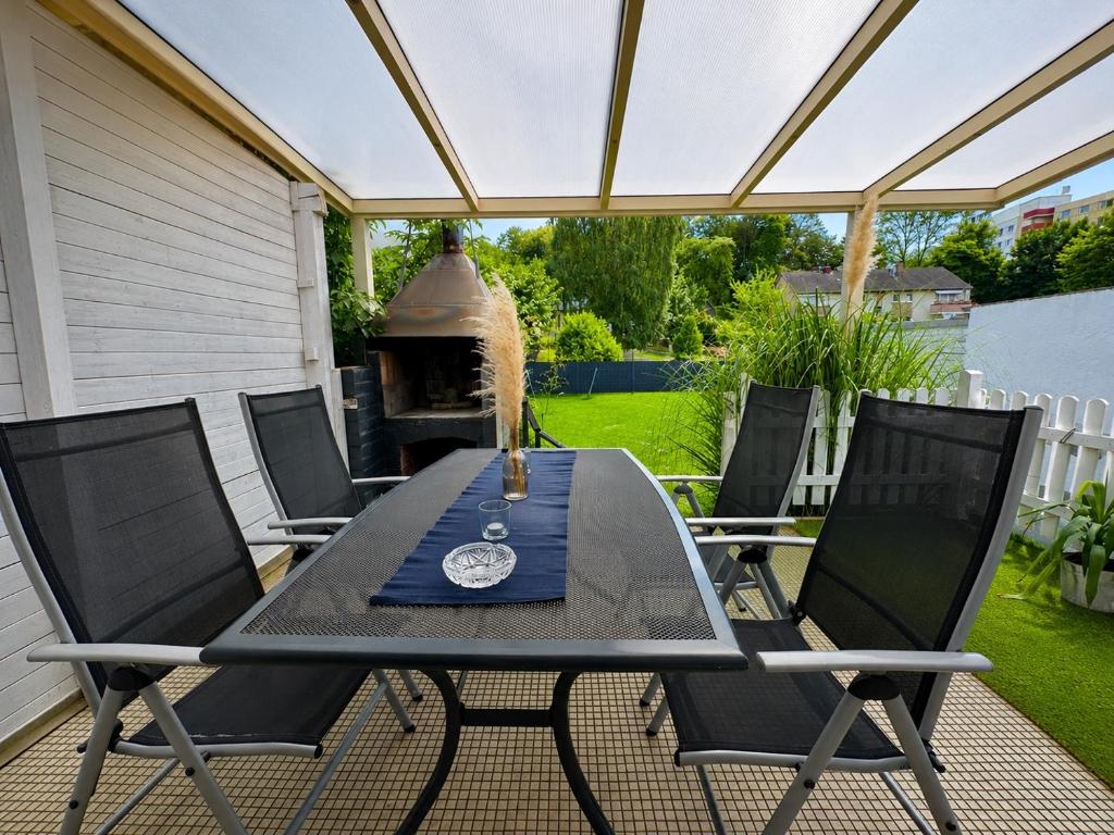 a patio with a table and chairs and a grill at Sweethome - Köln Messe in Bergisch Gladbach