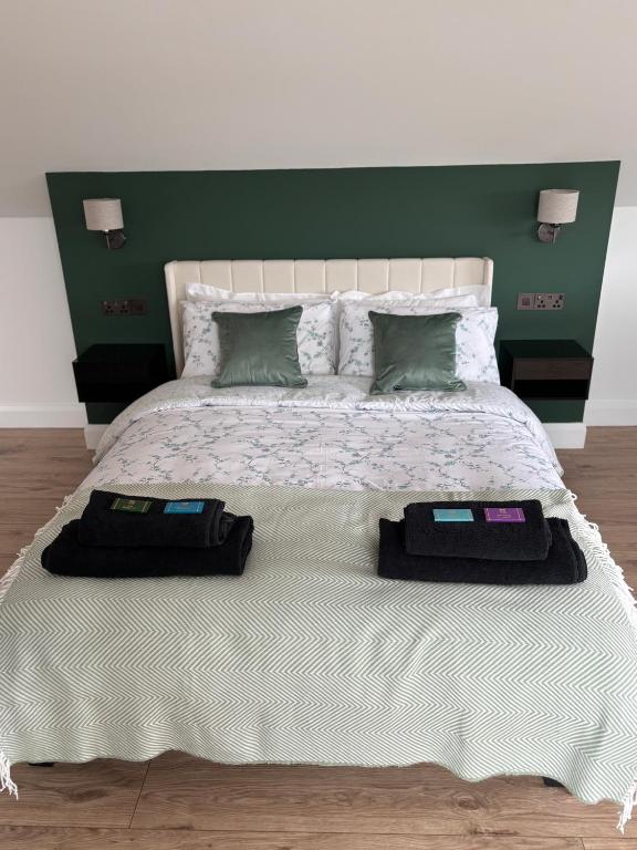 a bedroom with a large bed with a green headboard at Skellig Bliss in Valentia Island