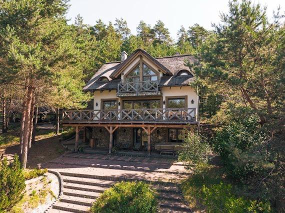a large house with a balcony on top of it at Dom pod strzechą in Swornegacie