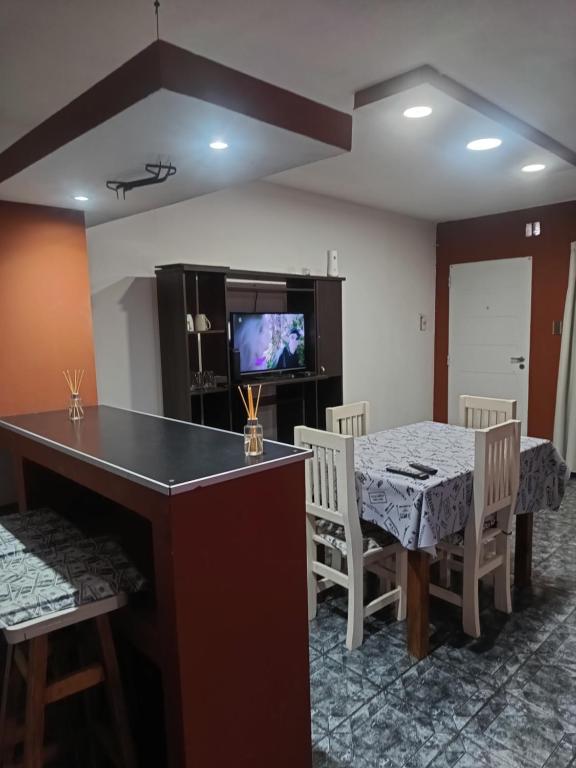 a dining room with a table and chairs and a television at depto felix 1 in Santa Rosa