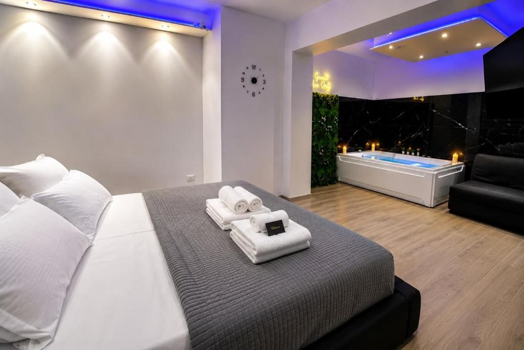 a bedroom with a bed and a bathtub with towels at Seven Suite SPA in Fiumicino