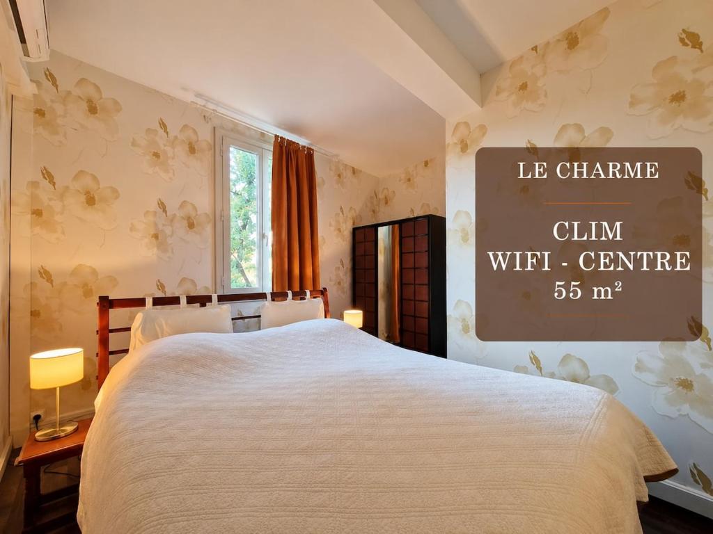 a bedroom with a bed and a sign on the wall at Le Charme in Eauze