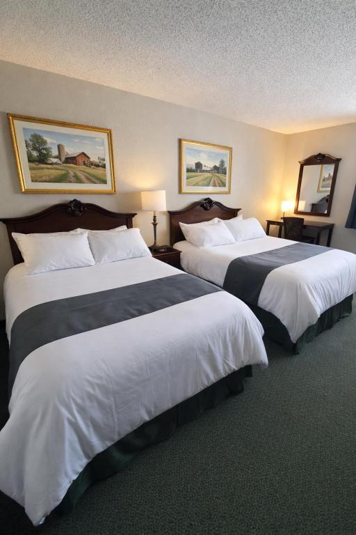 a hotel room with two beds with white and black sheets at The Jeffreys Hotel Extended Stay in Osceola