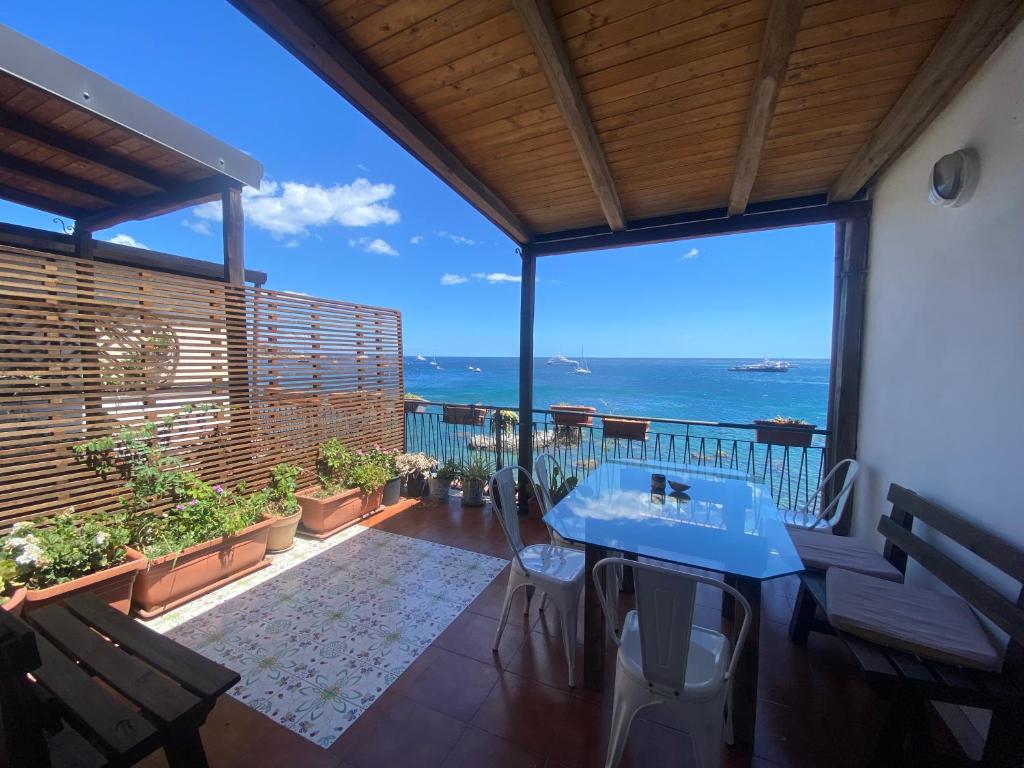 a balcony with a table and a view of the ocean at Teocle Beach rooms in Giardini Naxos