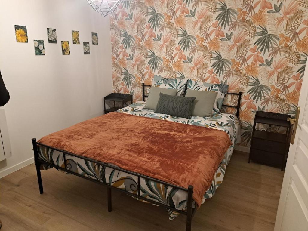 a bedroom with a bed with a tropical wallpaper at Domaine de la Viloudard in Saint-Aignan