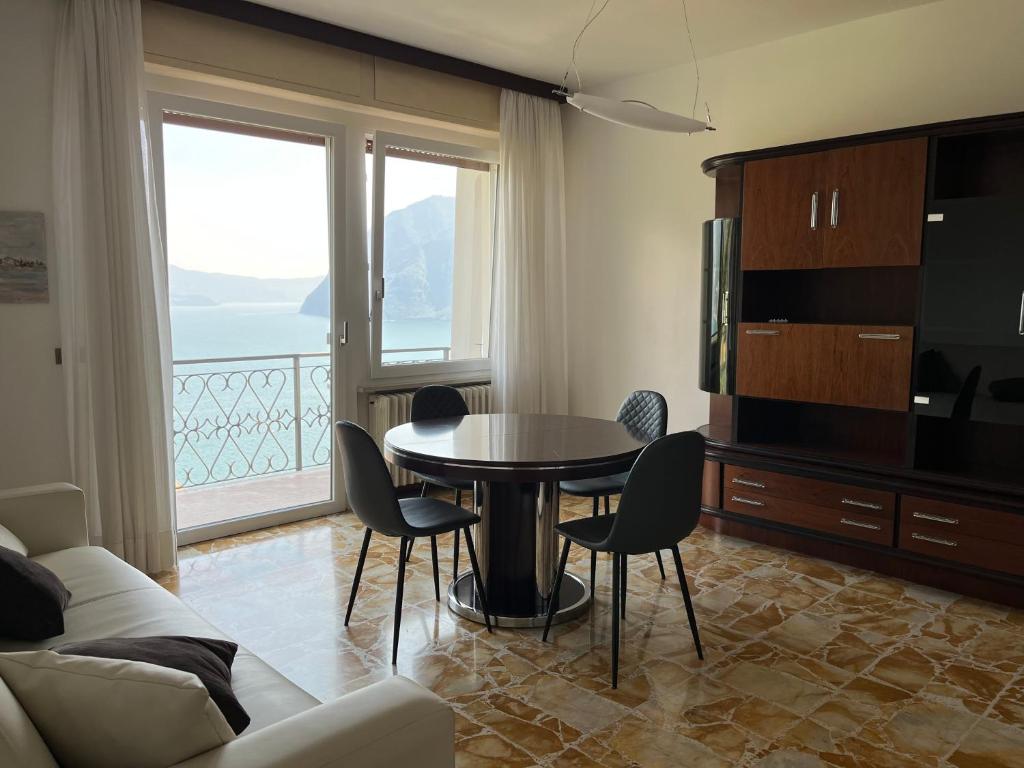 a living room with a table and chairs and a large window at Casa Antonio in Riva di Solto