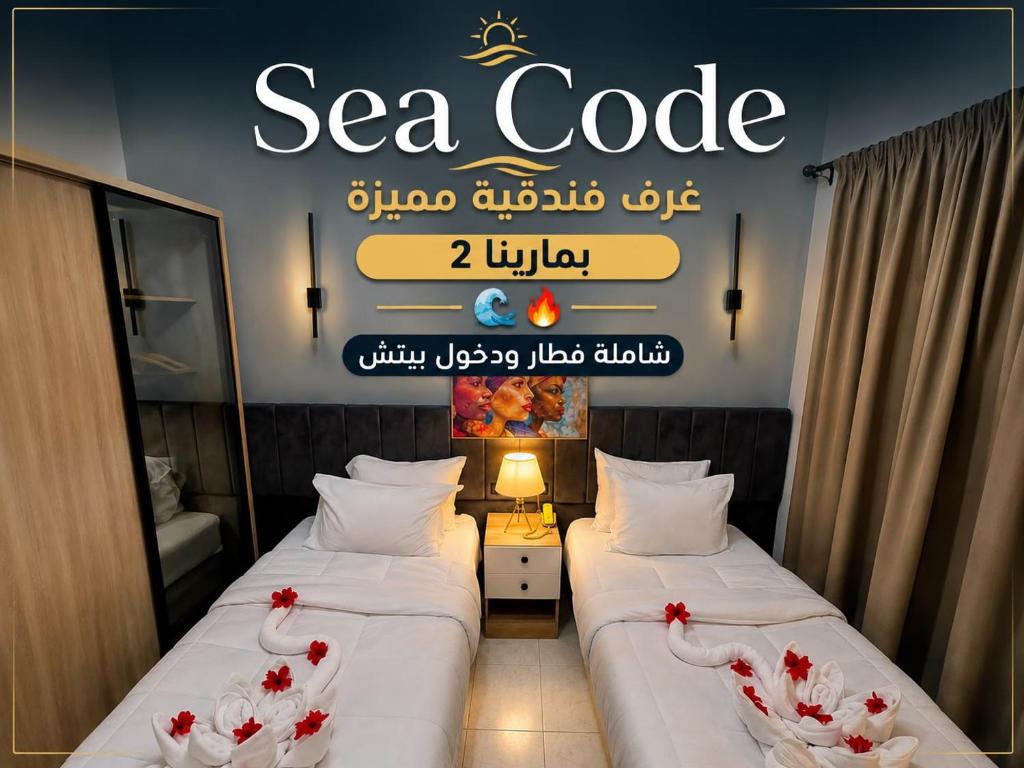 two beds in a hotel room with a sign on the wall at SEACODE Hotel in El Alamein