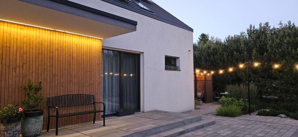 a patio with a bench and lights on a building at Sosenka in Niechorze