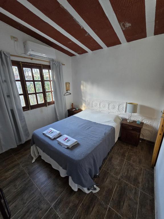 a bedroom with a large bed with a blue blanket at La Chiquitita in Villa Dolores