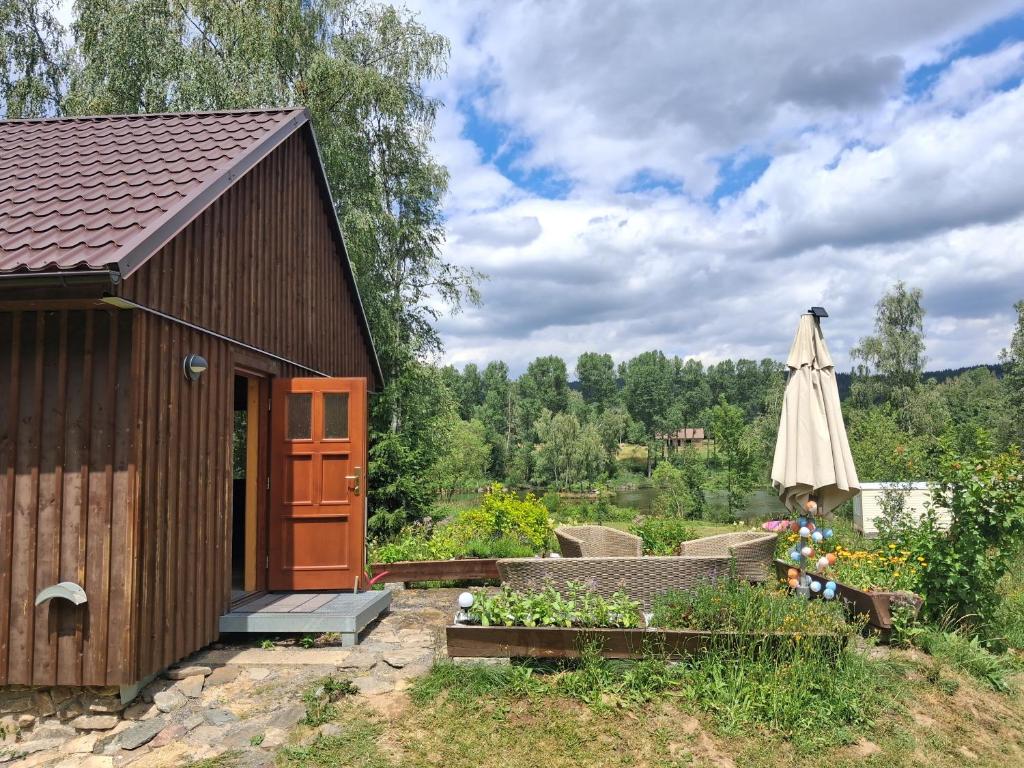 a small building with an umbrella next to a garden at Ádova chatová osada in Úbislav