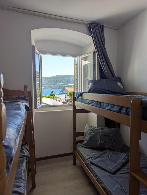 a room with two bunk beds and a window at Sanrise Hostel in Baošići