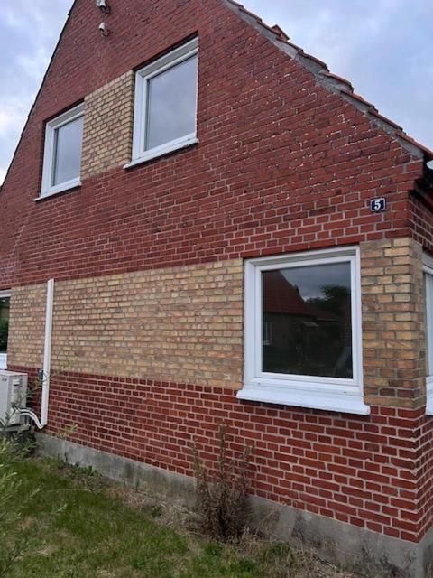 a brick house with two windows on the side of it at Hus i to plan i Nakskov by in Nakskov