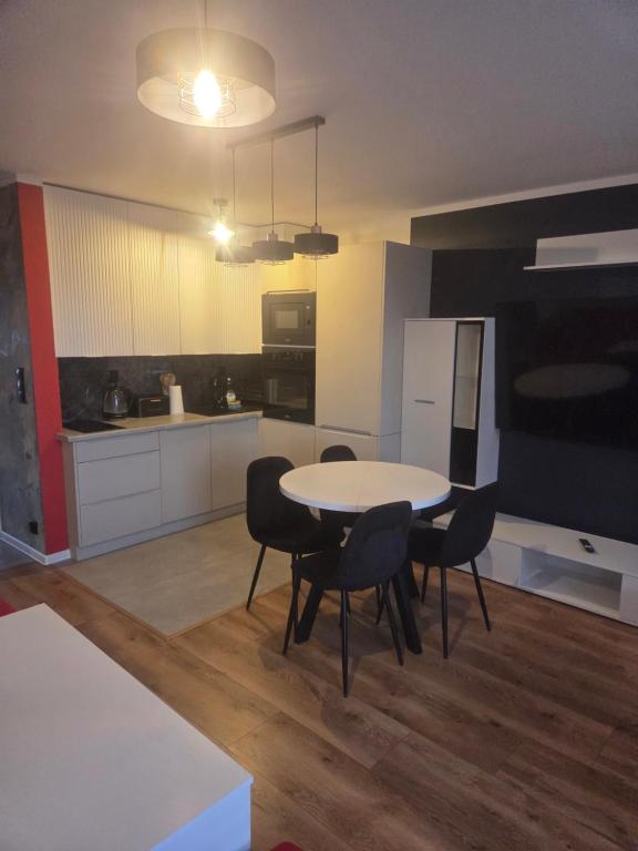 a kitchen with a table and chairs in a room at Apartament Słobódka in Słobódka