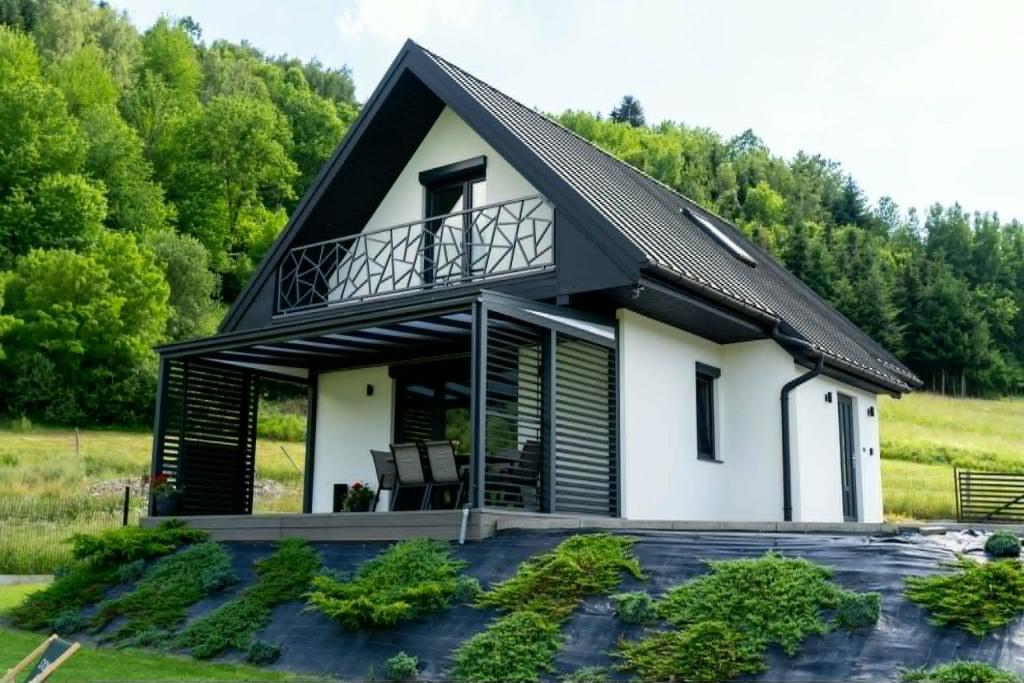 a house with a black roof at Domek pod Nowiną in Tylmanowa