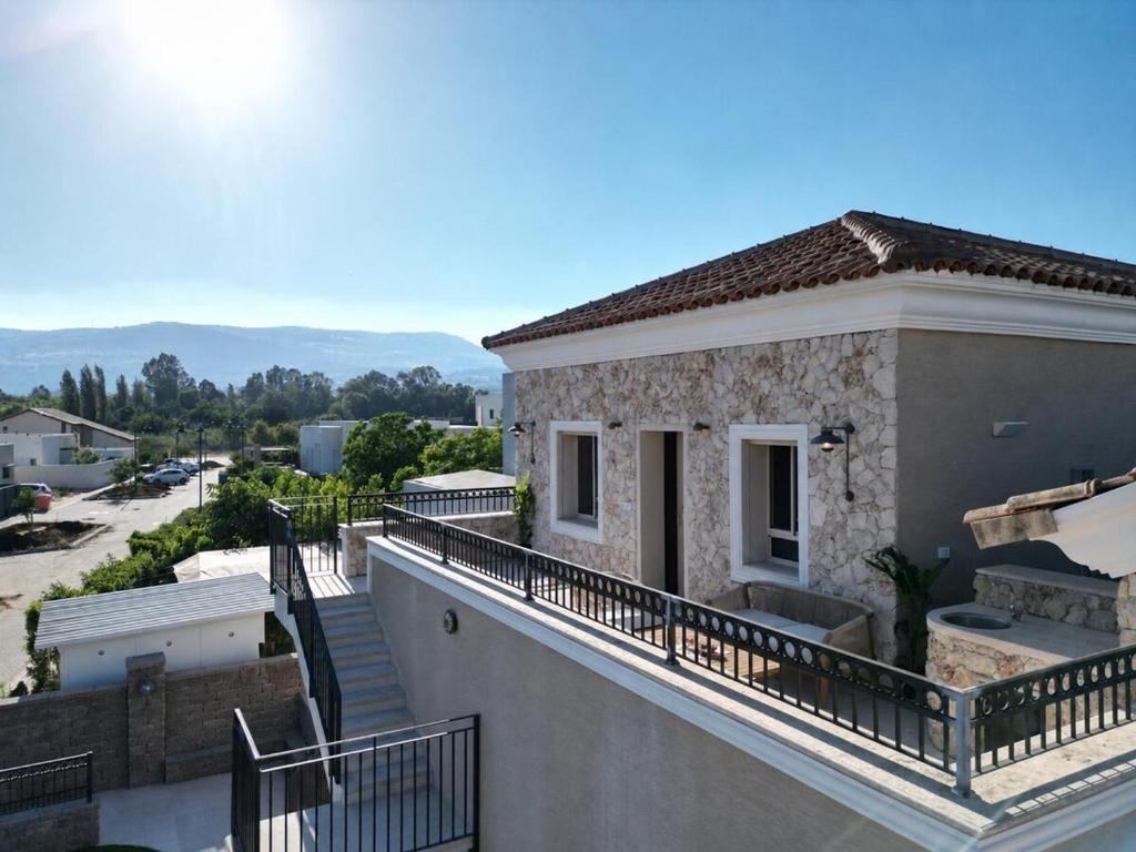 a house with a balcony with a view of a street at Pinat HaNahal in HaGoshrim