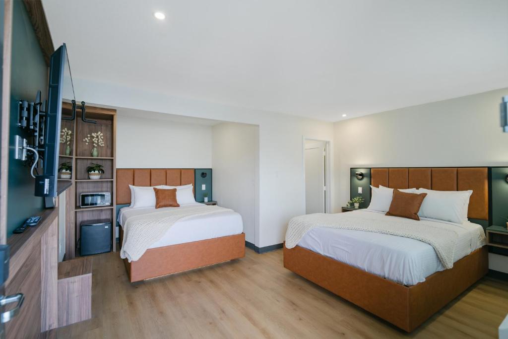 a bedroom with two beds and a tv in it at Nox Hotel - Studio City in Studio City