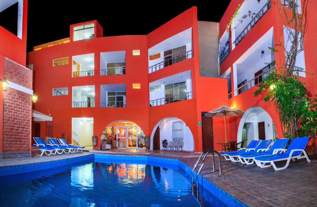 un hôtel avec une piscine en face d'un bâtiment dans l'établissement Hotel Princess, à Ica