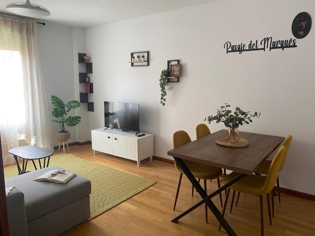 a living room with a table and a tv at El Pasaje del Marqués in El Burgo de Osma