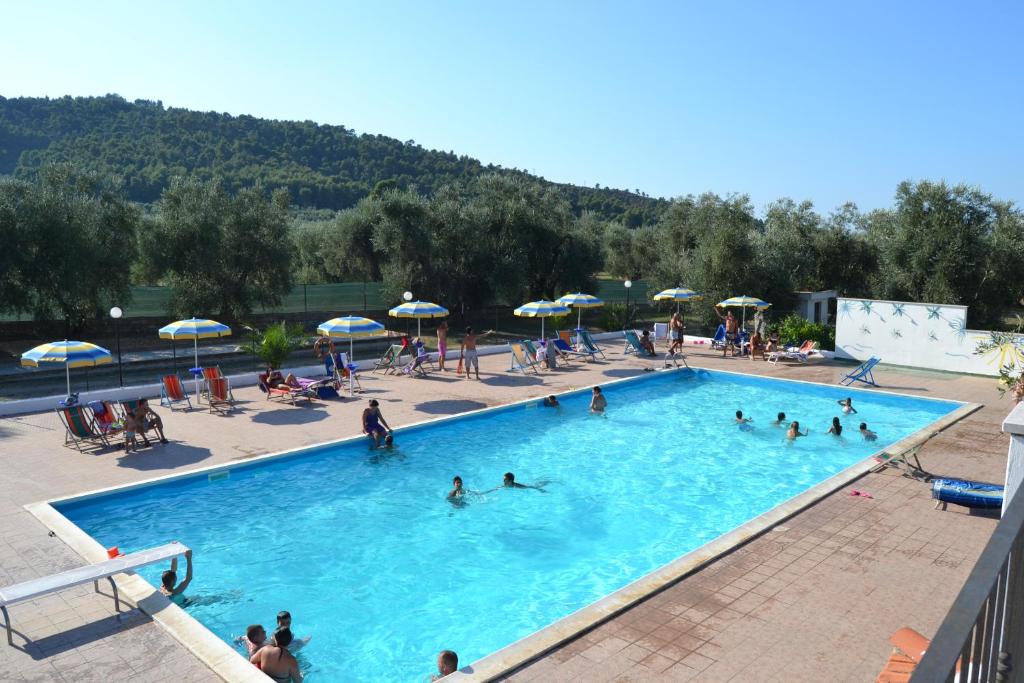 un grupo de personas en una piscina con sombrillas en Funno Delle Noci, en Peschici