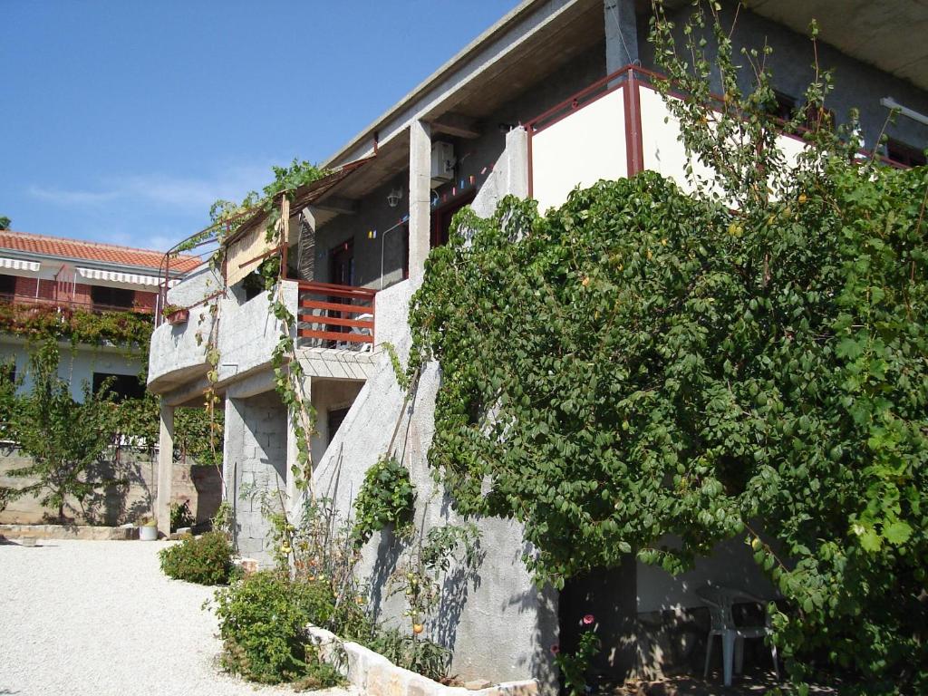 a building with a tree in front of it at Studio Apartment in Rogoznica