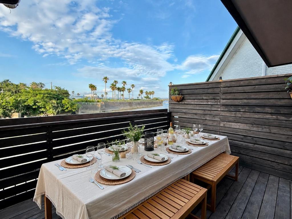 a table with plates and glasses on a balcony at 鴨川ビーチハウス in Kamogawa
